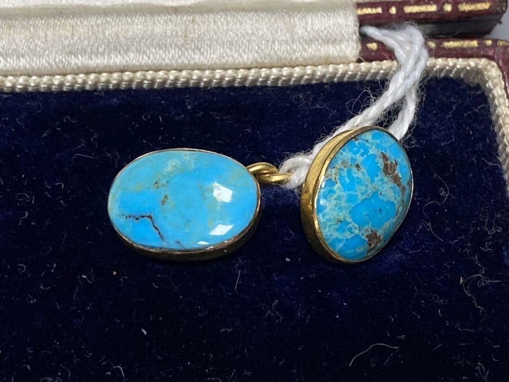 A pair of yellow metal and oval turquoise cabochon set cufflinks, stone length approx. 12mm, gross 6.1 grams,